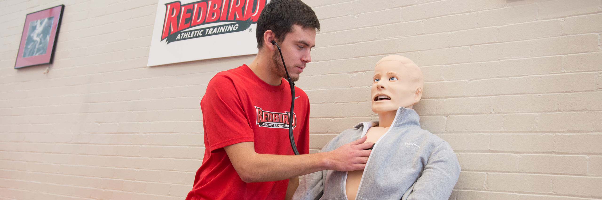 Student examines a medical dummy.