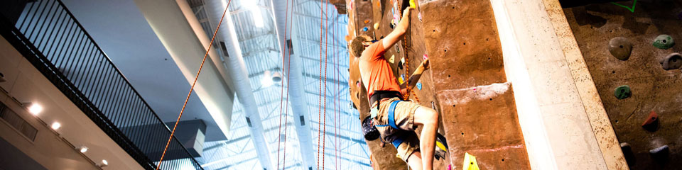 Person climbs an indoor rock wall.