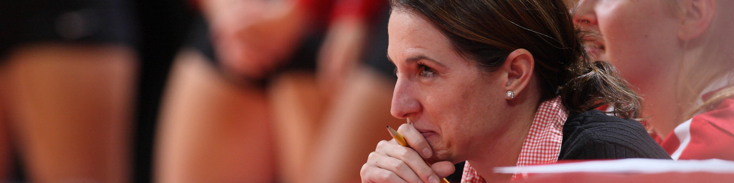 Volleyball coach watches her players perform.