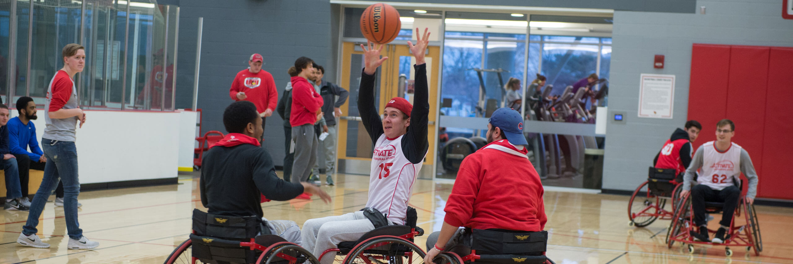 Students play basketball while in wheelchairs at Adaptapalooza.